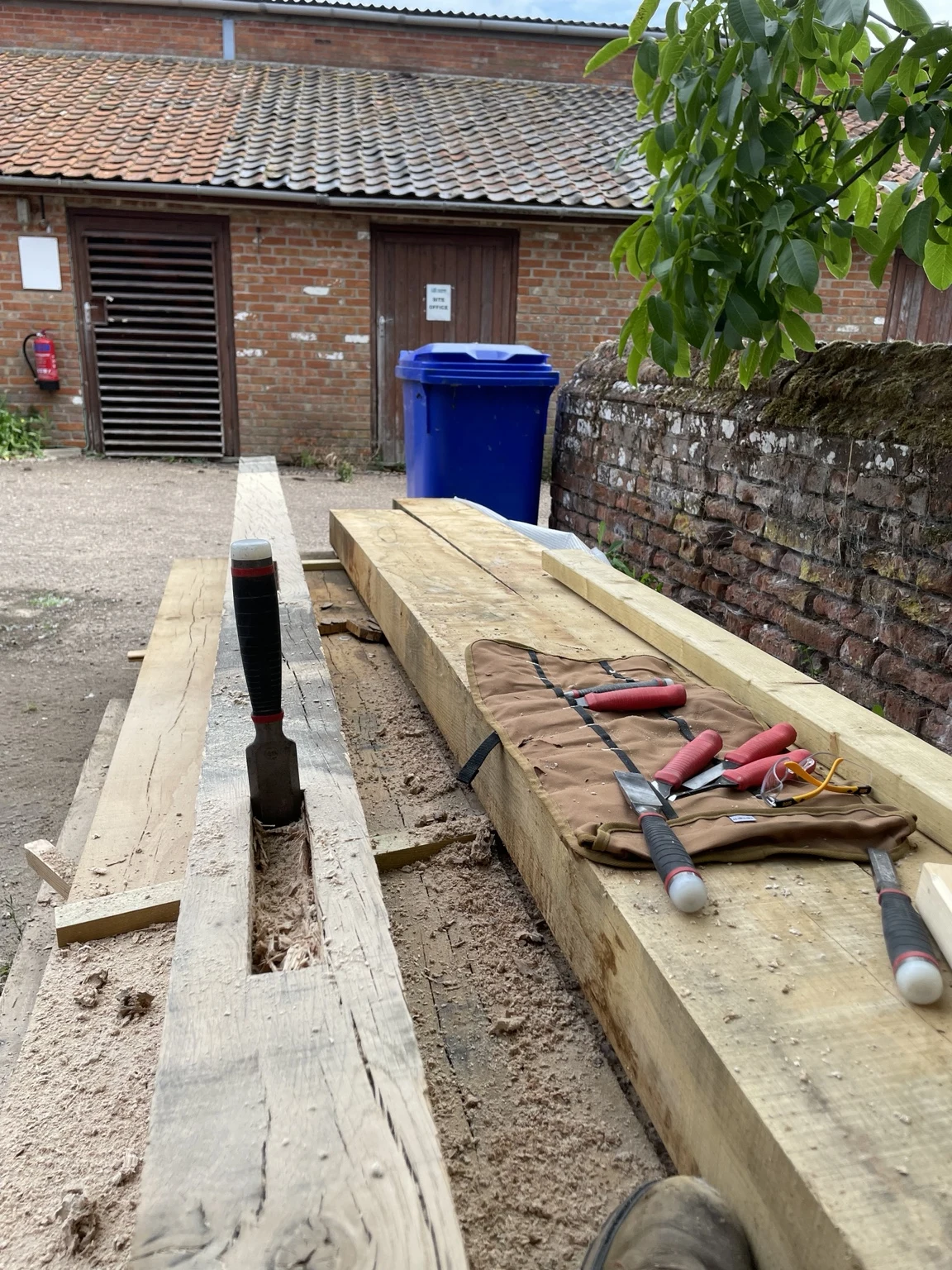Timber beams and carpentry tools laid out for joinery work