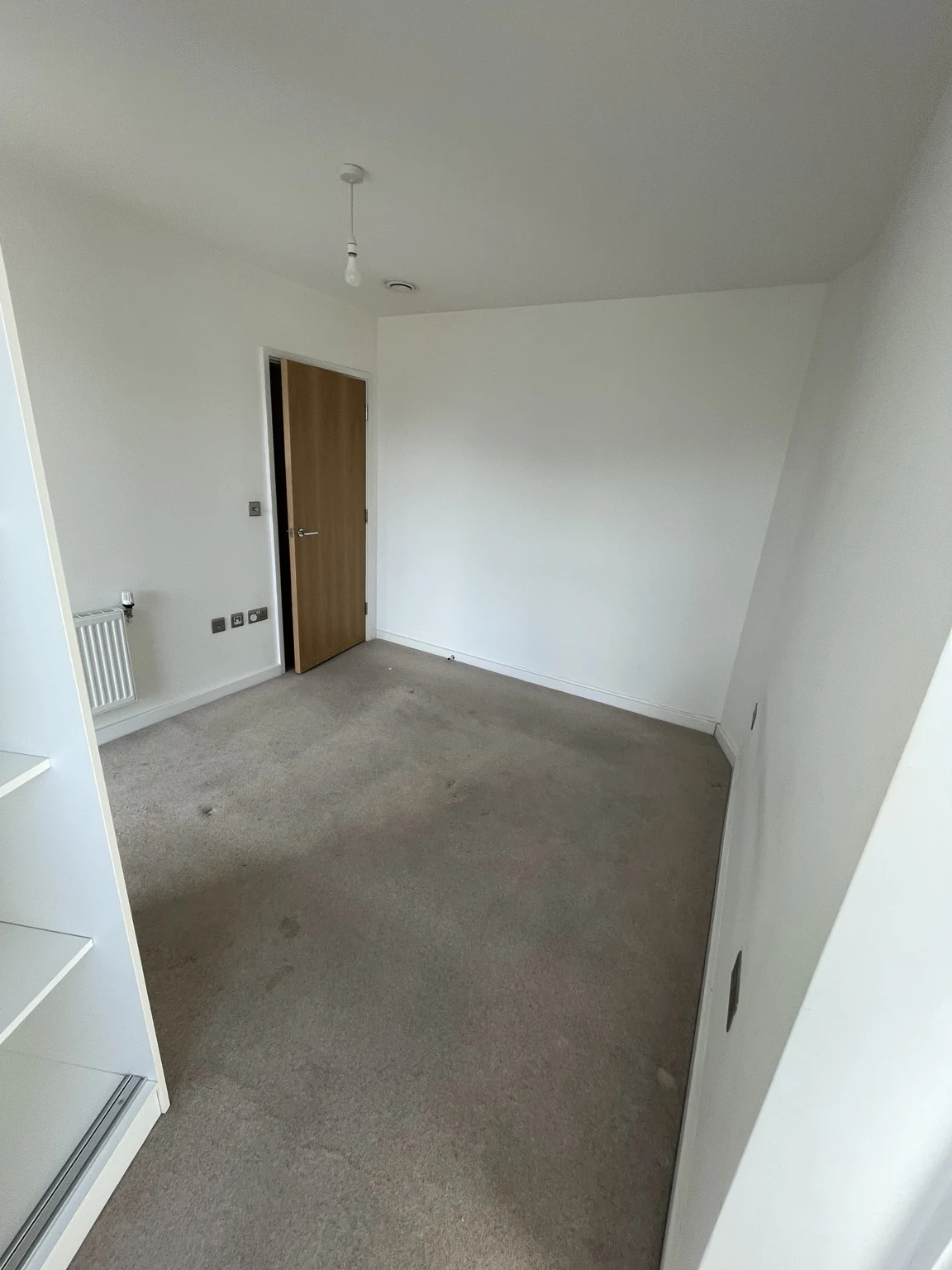 Refurbished room with carpet and timber door