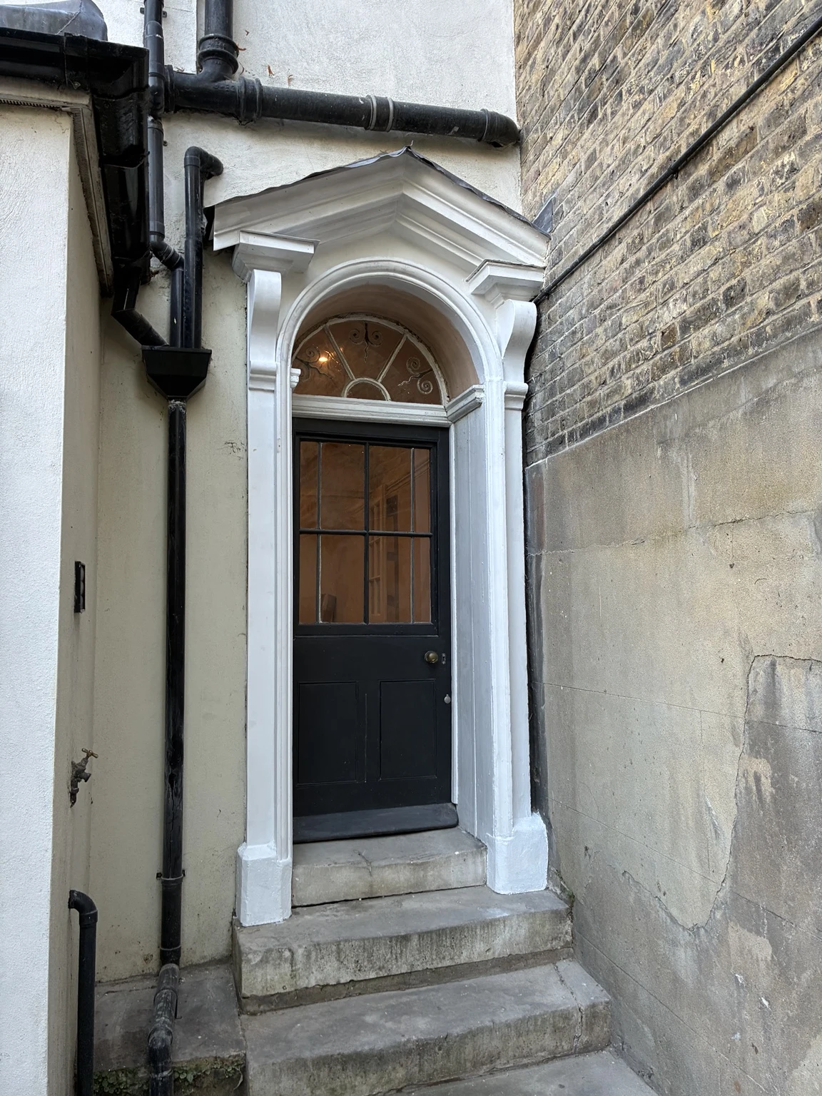 Restored entrance with decorative surround and dark front door